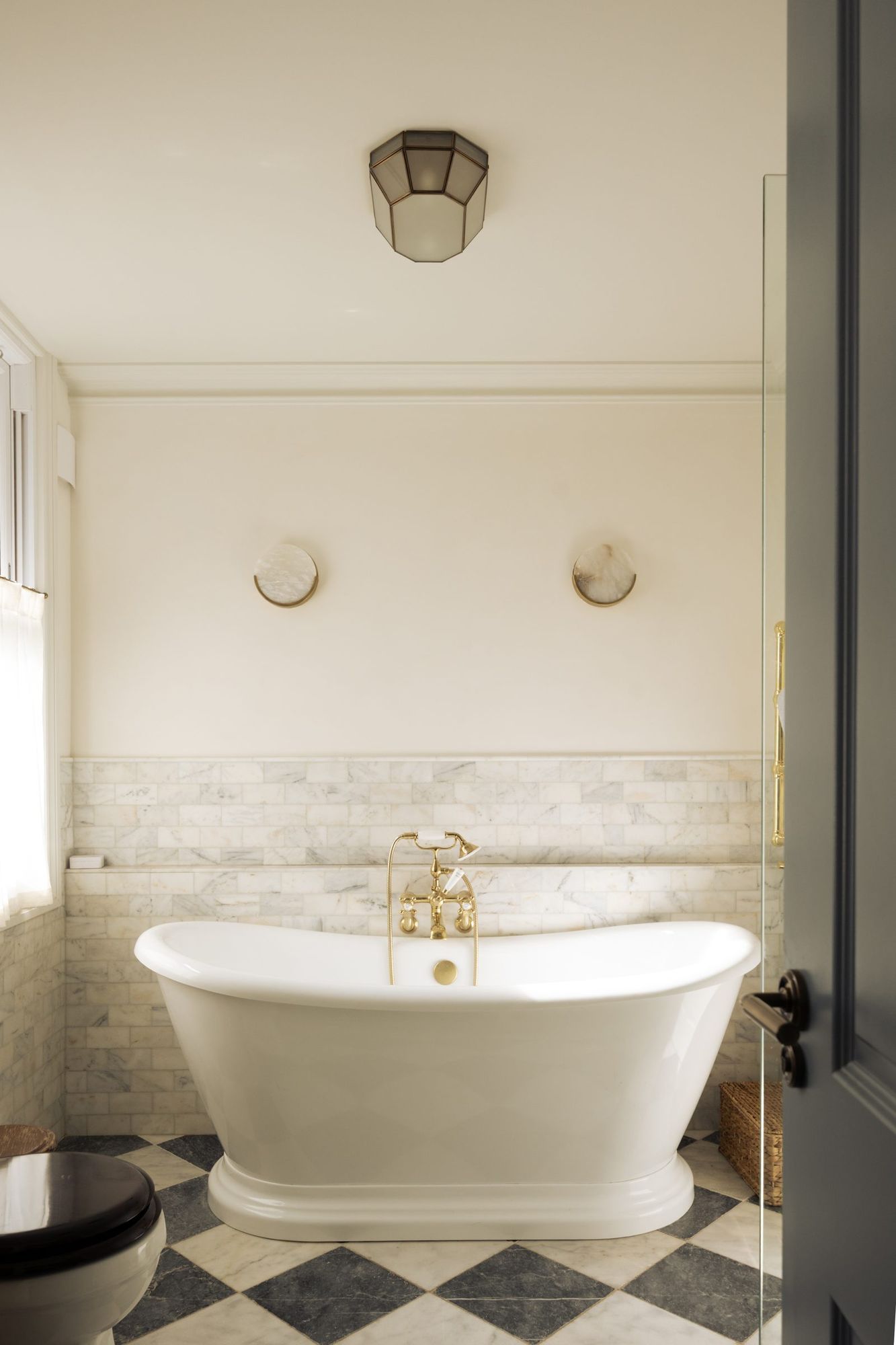 Bathroom with roll top bath on chequerboard marble