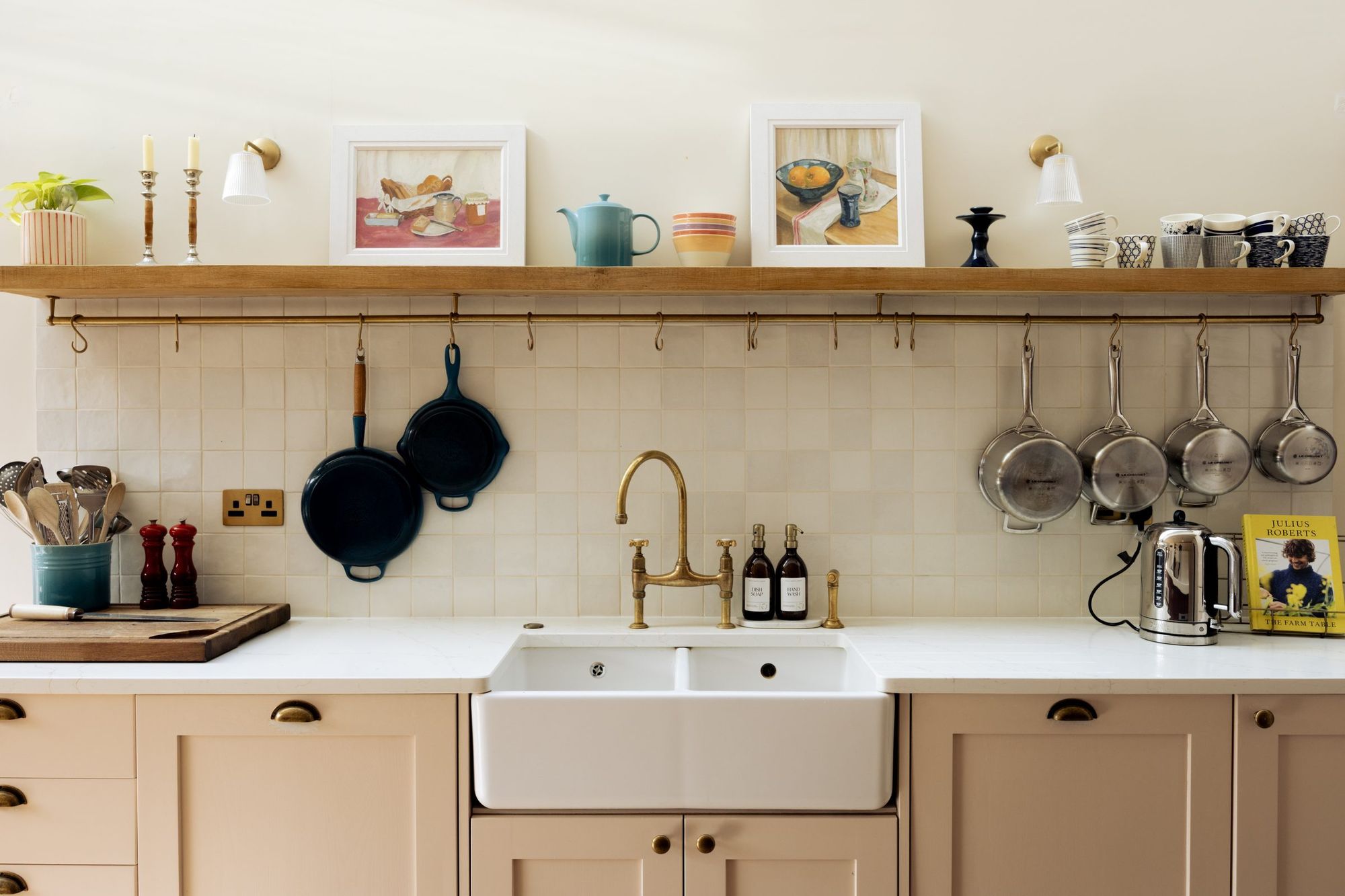 Kitchen sink wall with brass taps and hanging pans