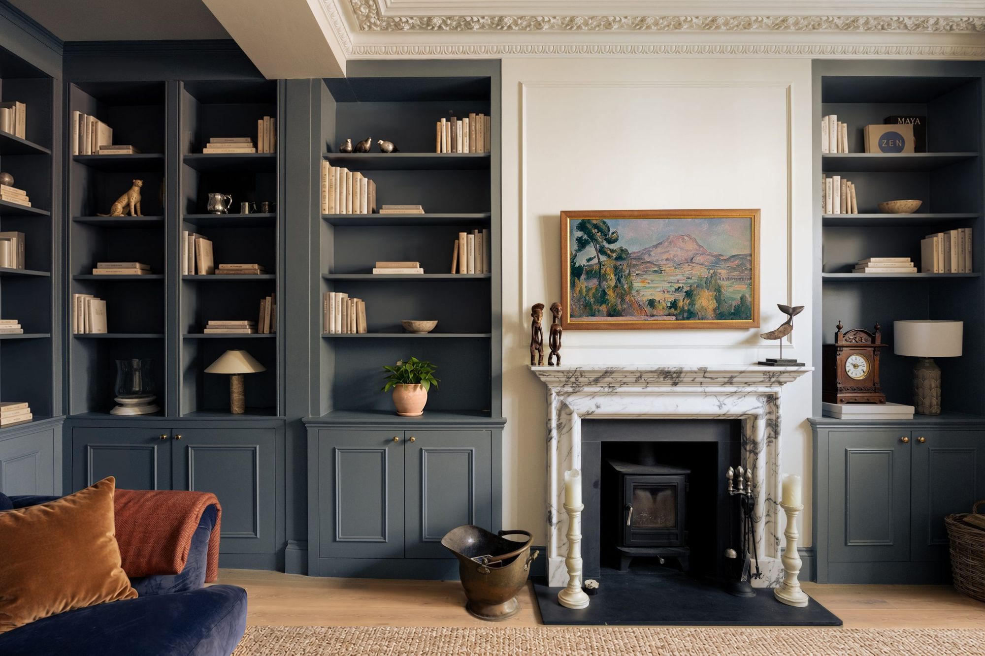Living room with blue-grey built-in shelving and marble fireplace