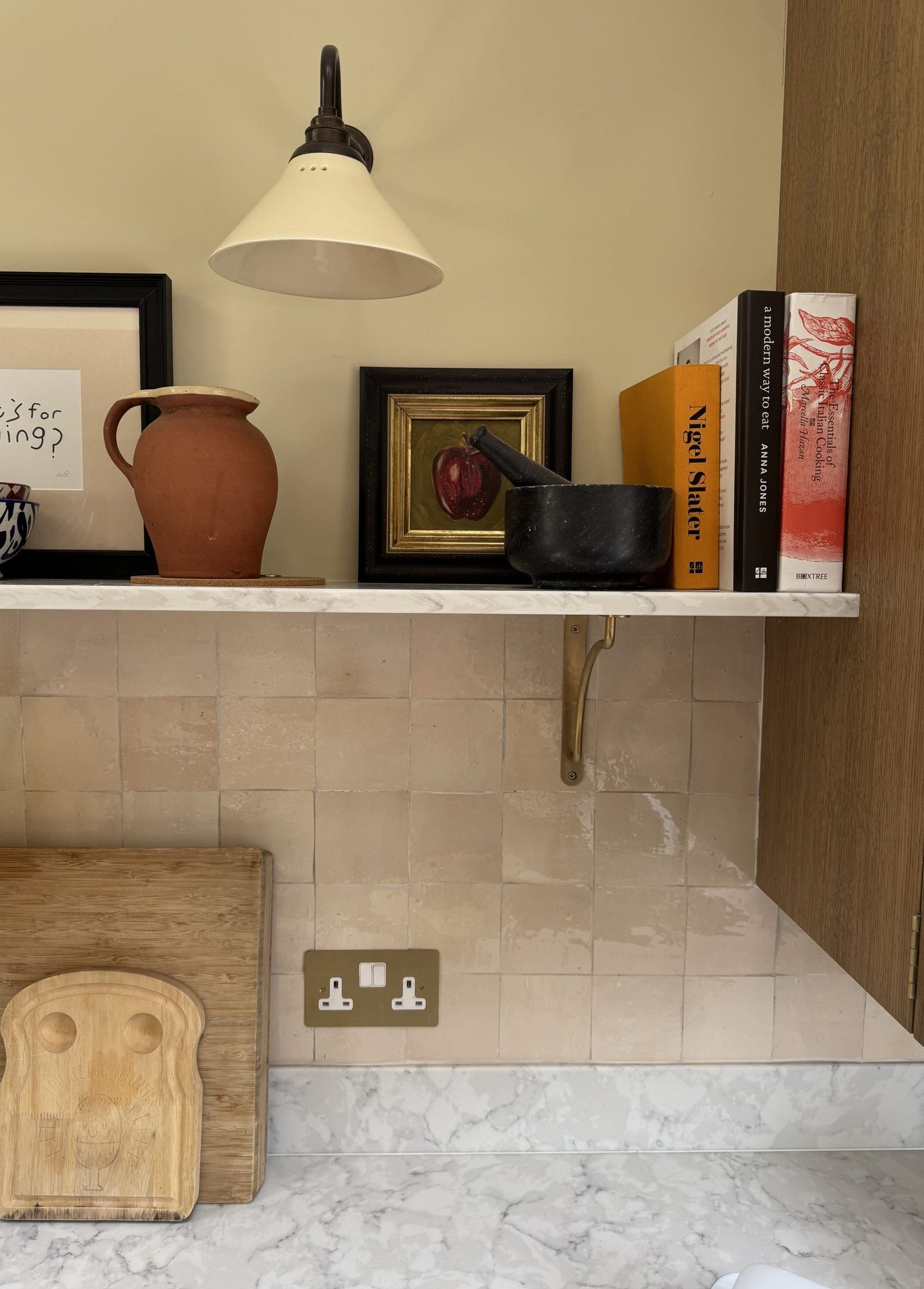 Kitchen shelf with wall light, books and ceramics