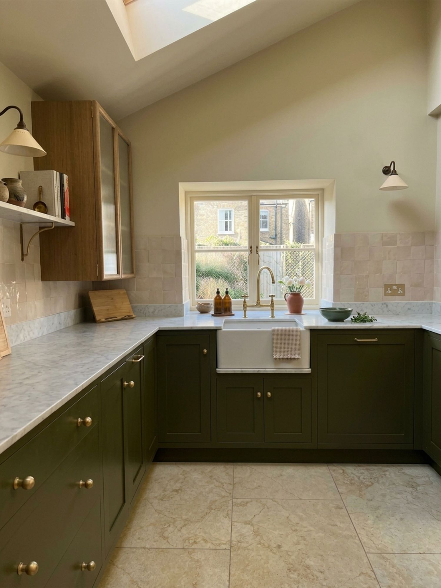 Kitchen with olive green cabinetry, marble worktops and a butler sink under the window